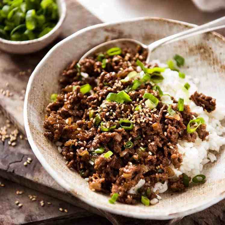 Asian Beef Bowls (ground beef recipe) served over rice garnished with scallions, ready to be eaten