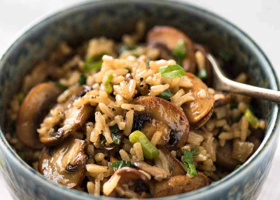 Mushroom Rice in a rustic blue bowl with a fork, ready to be eaten