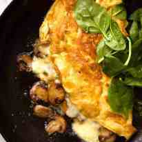 Overhead photo of Cheesy Omelette with Garlic Butter Mushrooms in a skillet.