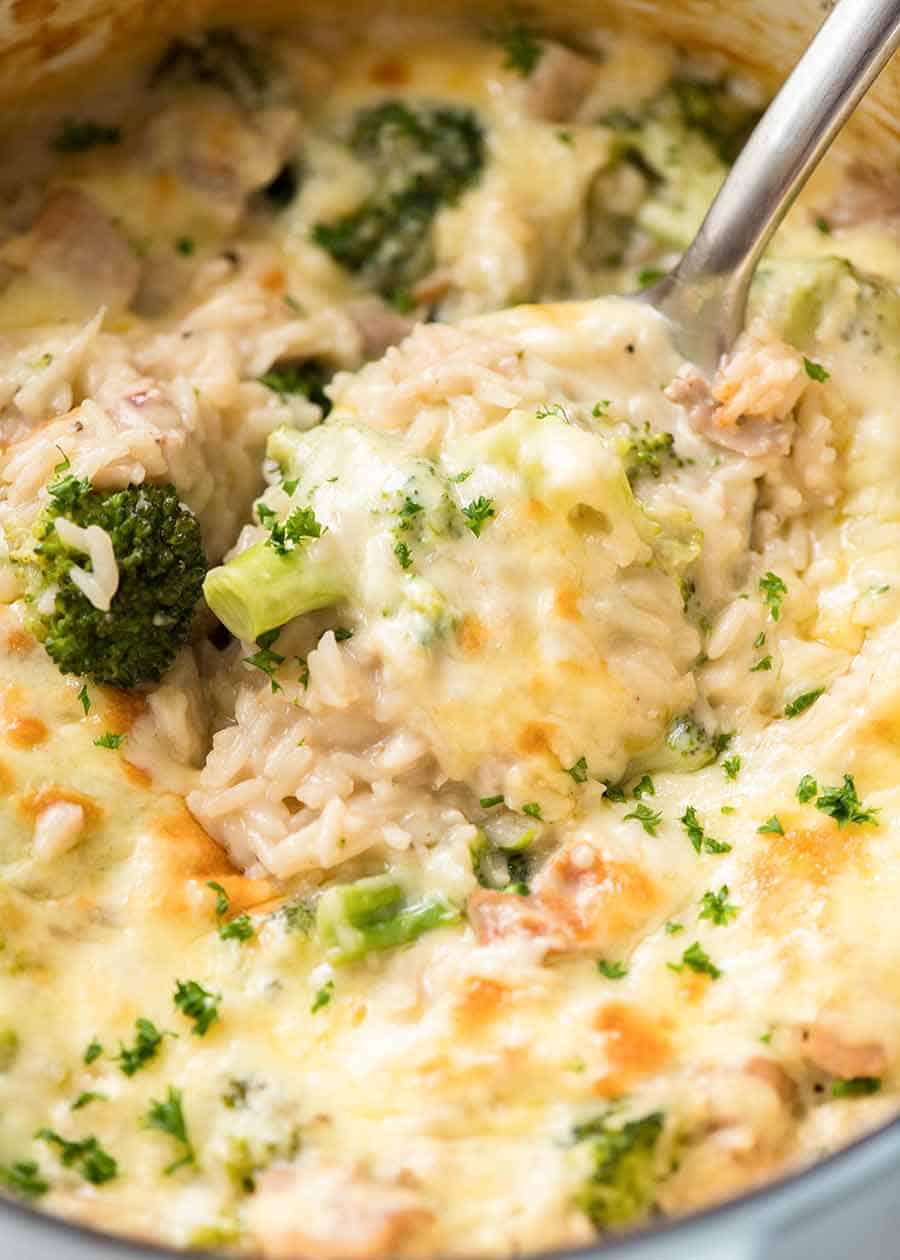Close up of spoon scooping up Chicken Broccoli Rice Casserole from the pot