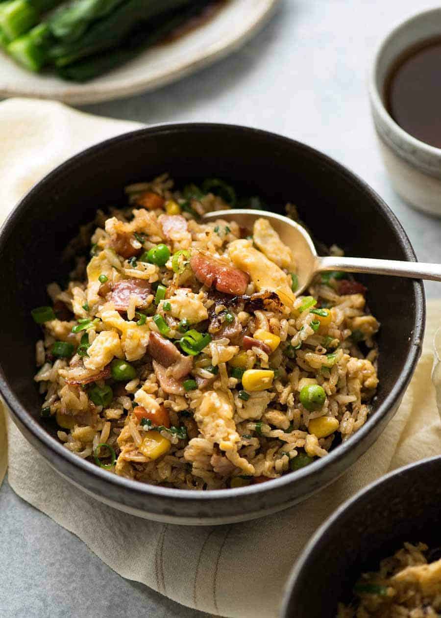 Close up of Egg Fried Rice in a dark brown bowl, ready to be eaten