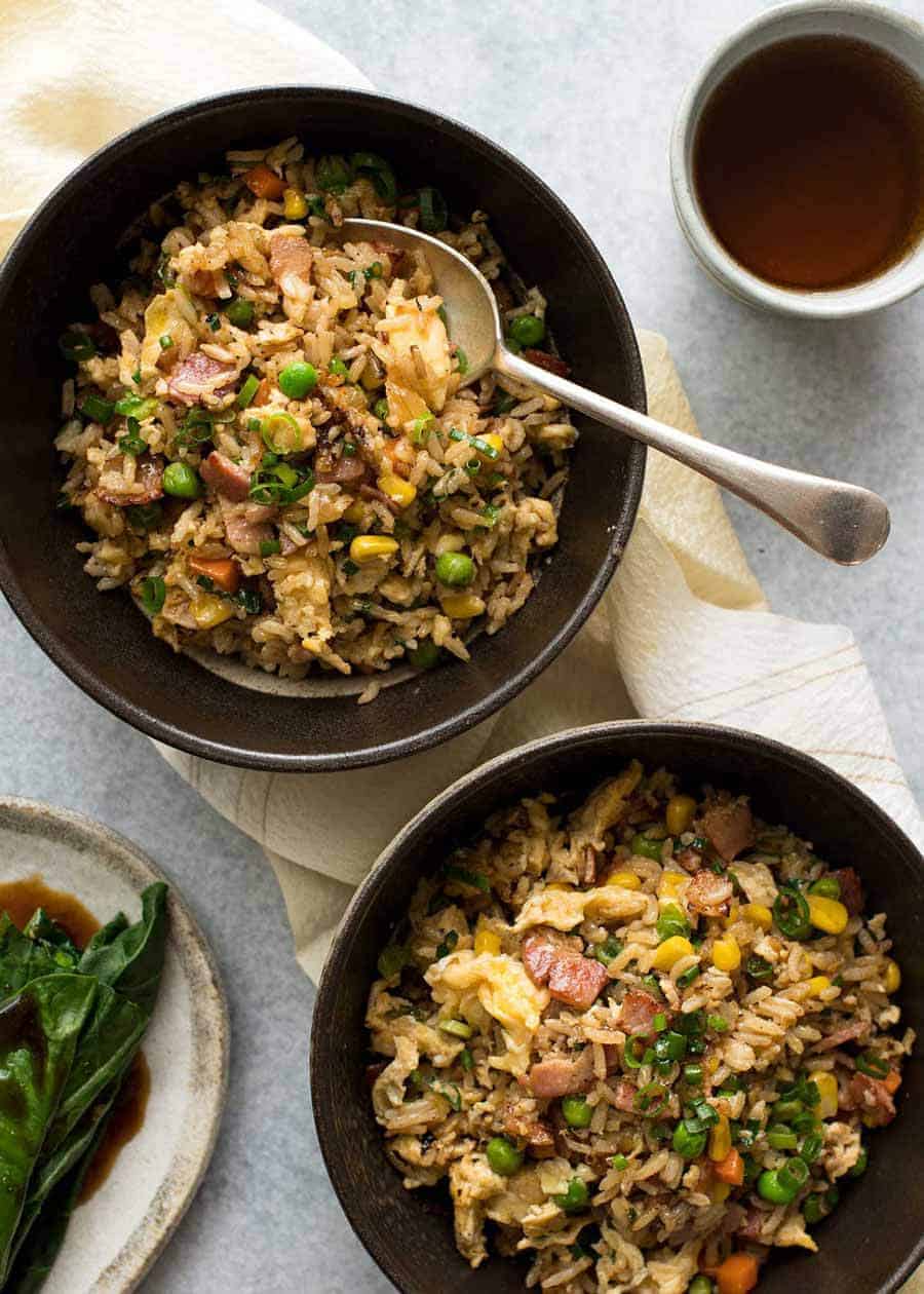 Overhead photo of 2 dark brown bowls with Egg Fried Rice, ready to be eaten