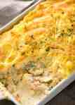 Close up of Fish Pie in white baking dish showing creamy filling with fish flakes