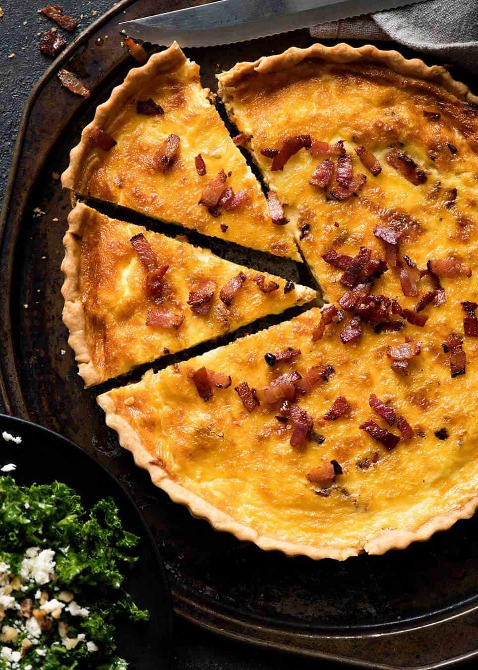 Overhead photo of a golden Quiche Lorraine with 2 pieces cut