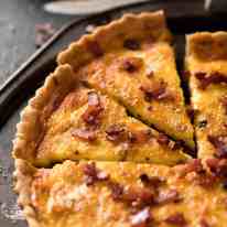 Photo of quiche lorraine on a rustic metal serving tray