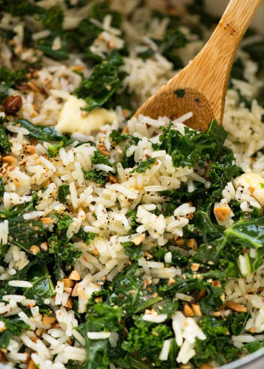 garlic butter rice and kale in bowl with wooden spoon