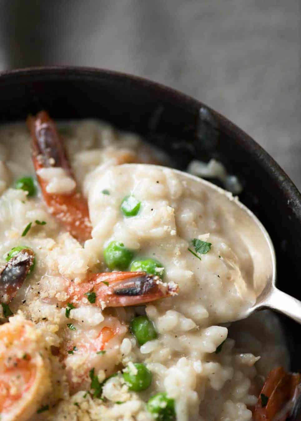 Close up of spoon scooping up Prawn Risotto to show how creamy it is.