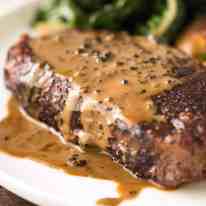 Close up of Creamy Peppercorn Sauce dripping down the side of steak