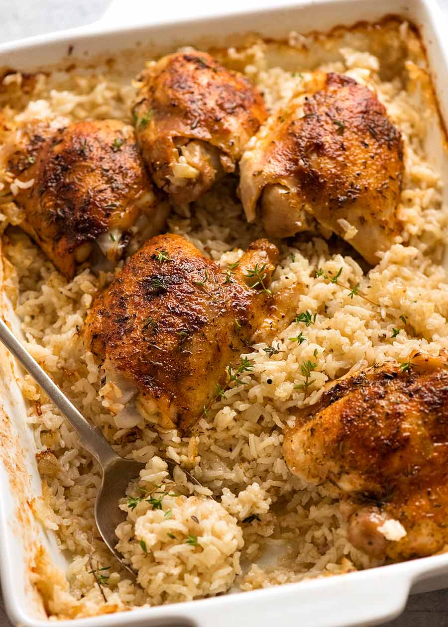 White baking dish with baked chicken and rice, ready to be served