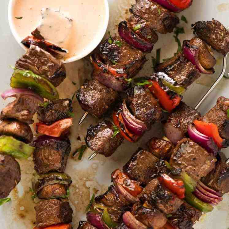 Overhead photo of Marinated Beef Kabobs with a pink sauce