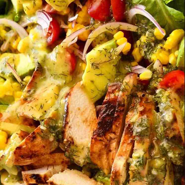 Close up of Lemon Chicken Salad with avocado, tomatoes and corn with lemon dill dressing.