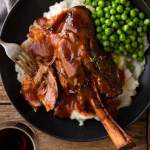 Slow Cooked Lamb Shanks in Red Wine Sauce served with creamy mashed potato and peas