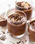 Chocolate Mousse in glasses topped with a dollop of cream and chocolate shavings, ready to be served