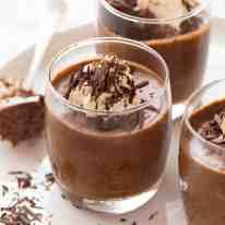 Chocolate Mousse in glasses topped with a dollop of cream and chocolate shavings, ready to be served