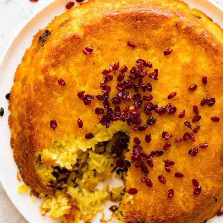 Overhead photo of Tachin Persian Saffron Rice sprinkled with barberries