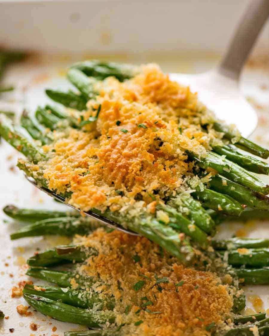 Close up of spatula scooping up Parmesan Roasted Green Beans