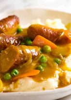 Curried Sausages over mash in a bowl, ready to be eaten