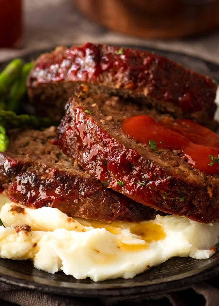 Close up of meatloaf recipe - slices served on mashed potatoes with ketchup