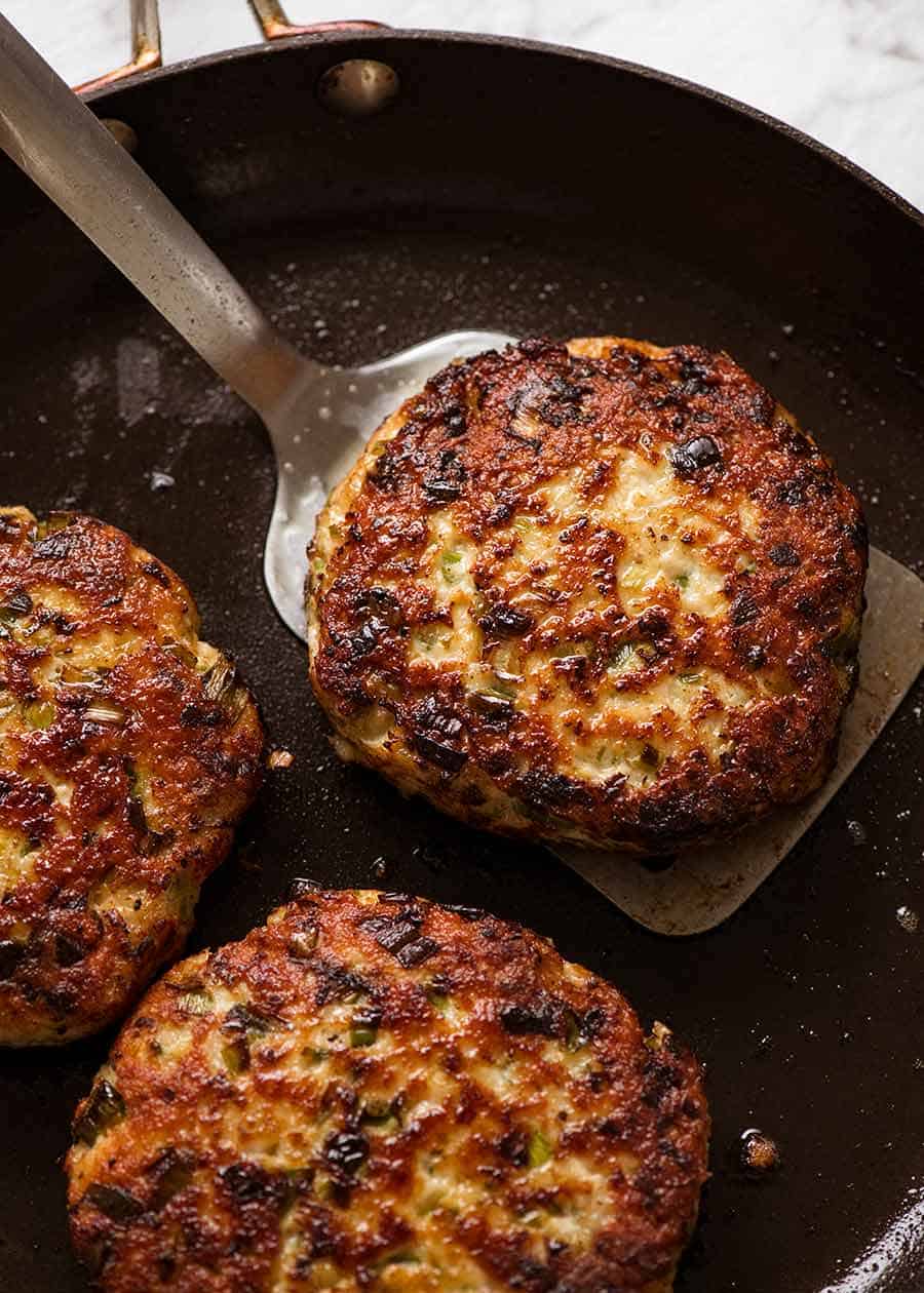 Close up of Chicken Burger Patties in a black skillet, fresh off the stove