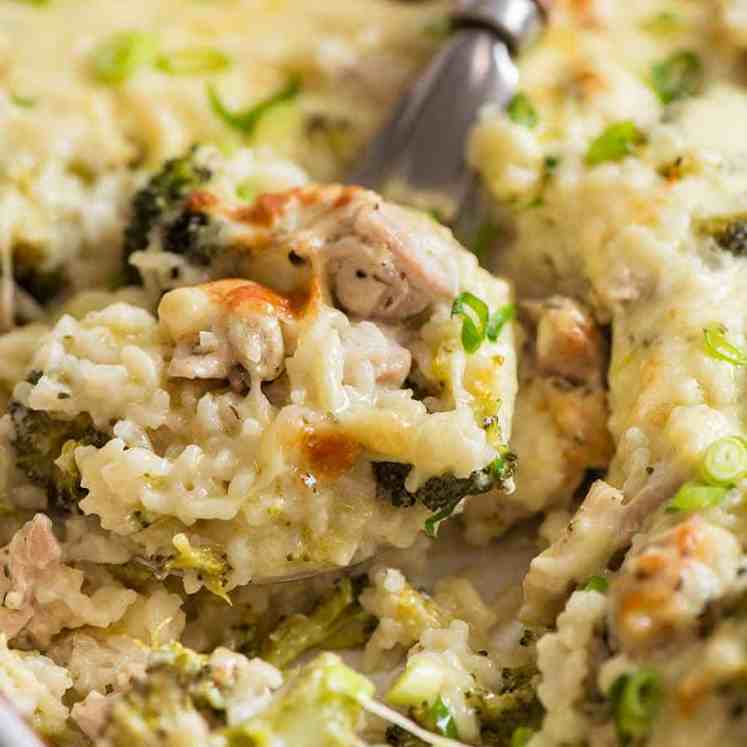 Close up of creamy Chicken Rice Casserole in a white baking dish, fresh out of the oven