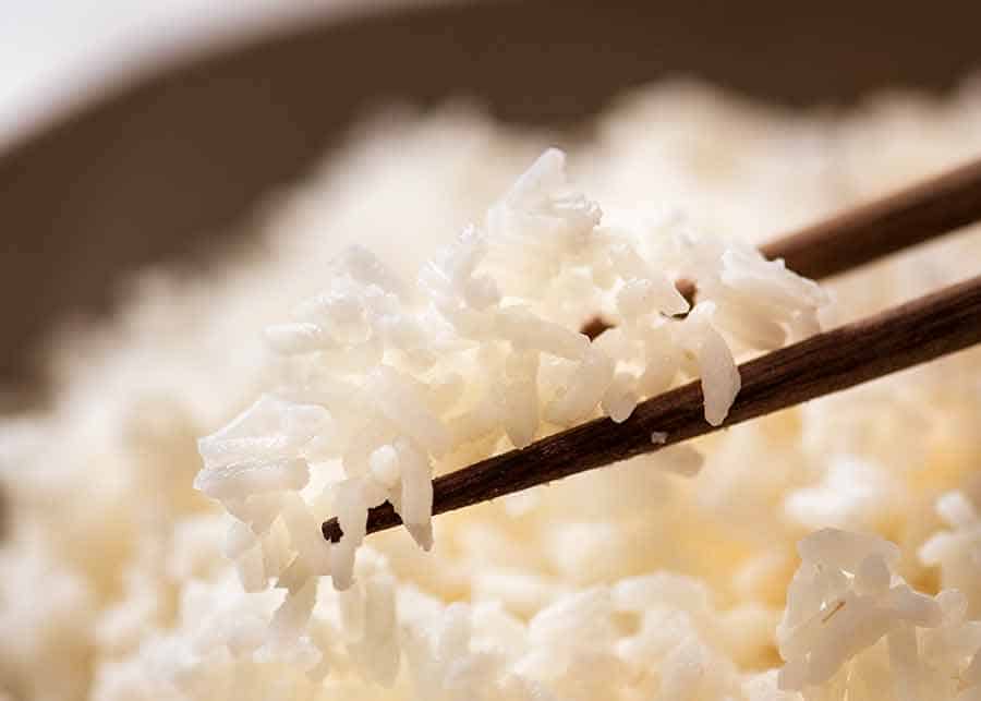 Close up photo of chopsticks holding white rice