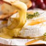 Scooping up Baked Brie with crispy cracker