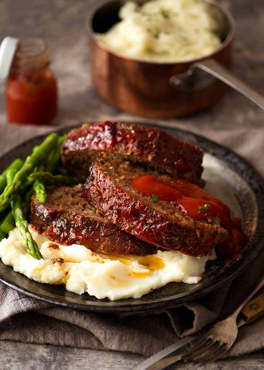 Slices of meatloaf with creamy mashed potatoes and steamed vegetables