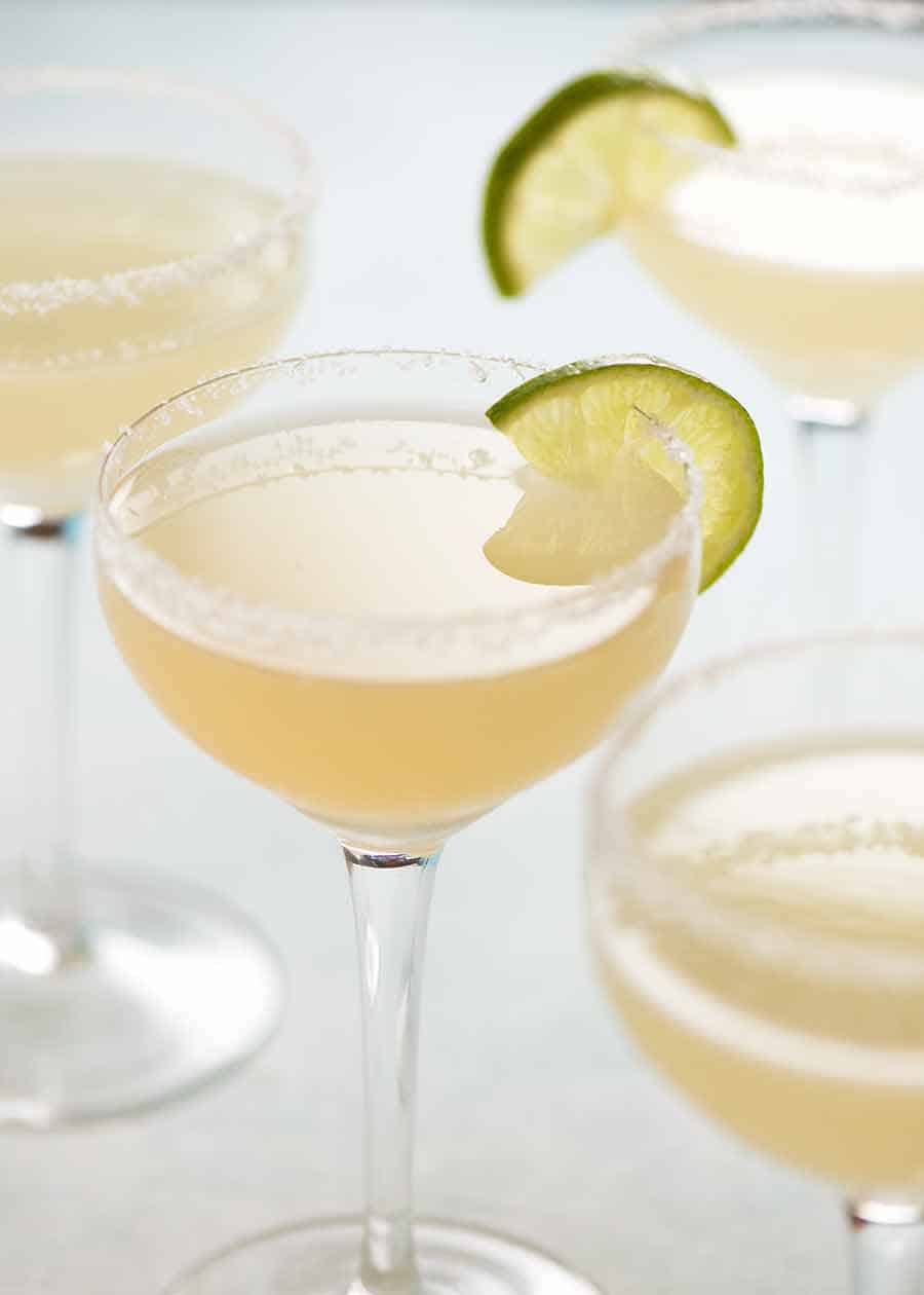Margaritas with lime wedges, ready to be served