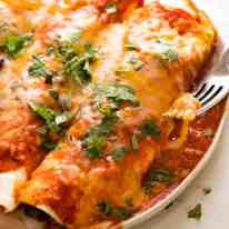 Plate of juicy Chicken Enchiladas, ready to be devoured