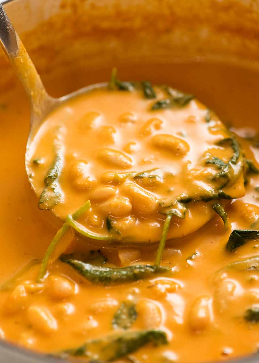 Ladling Creamy Tomato Bean Soup into bowls
