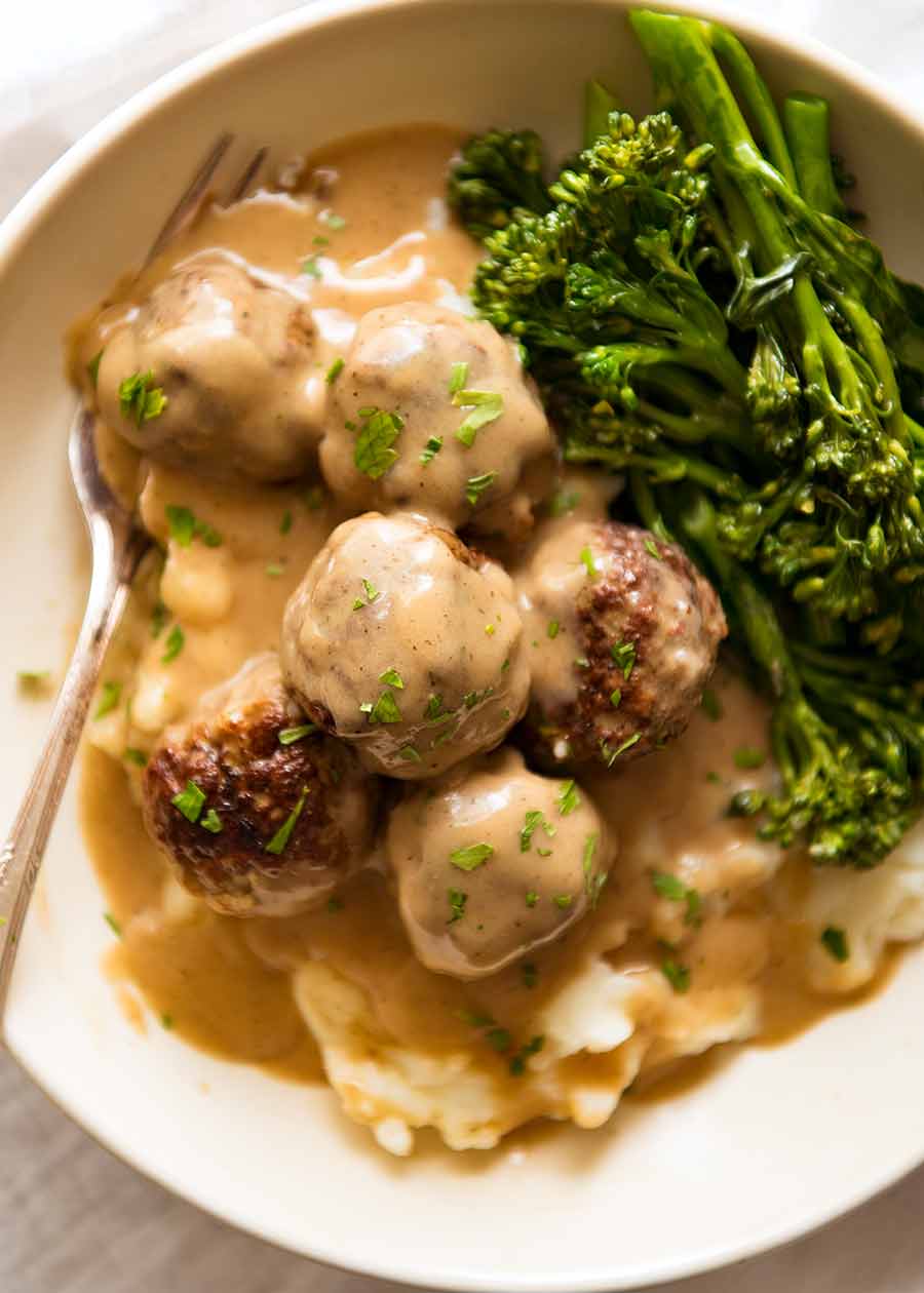 Swedish Meatballs on a plate served with creamy mashed potato and a side of steamed broccolini
