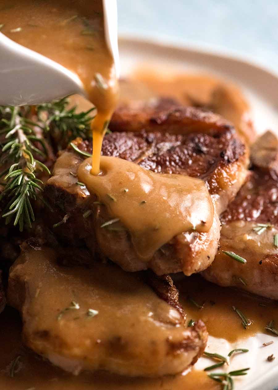 Pouring rosemary gravy over lamb chops