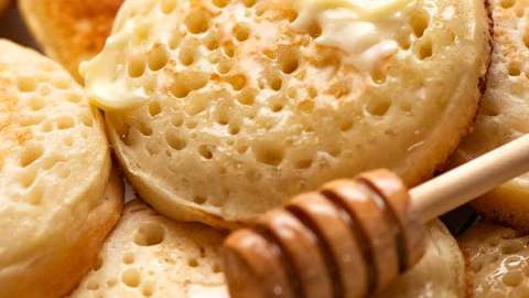 Close up of homemade crumpets with honey and butter