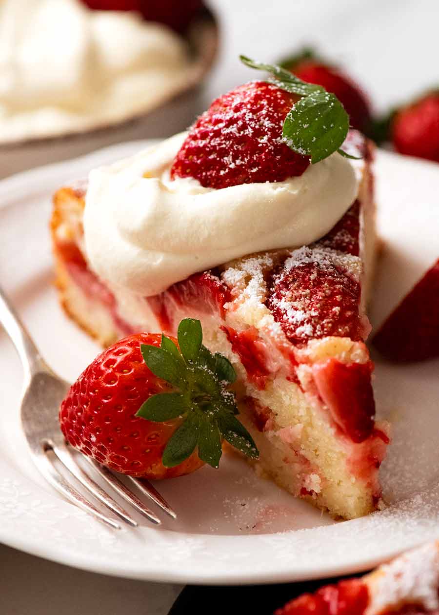 Slice of Easy Strawberry Cake with cream and fresh strawberries