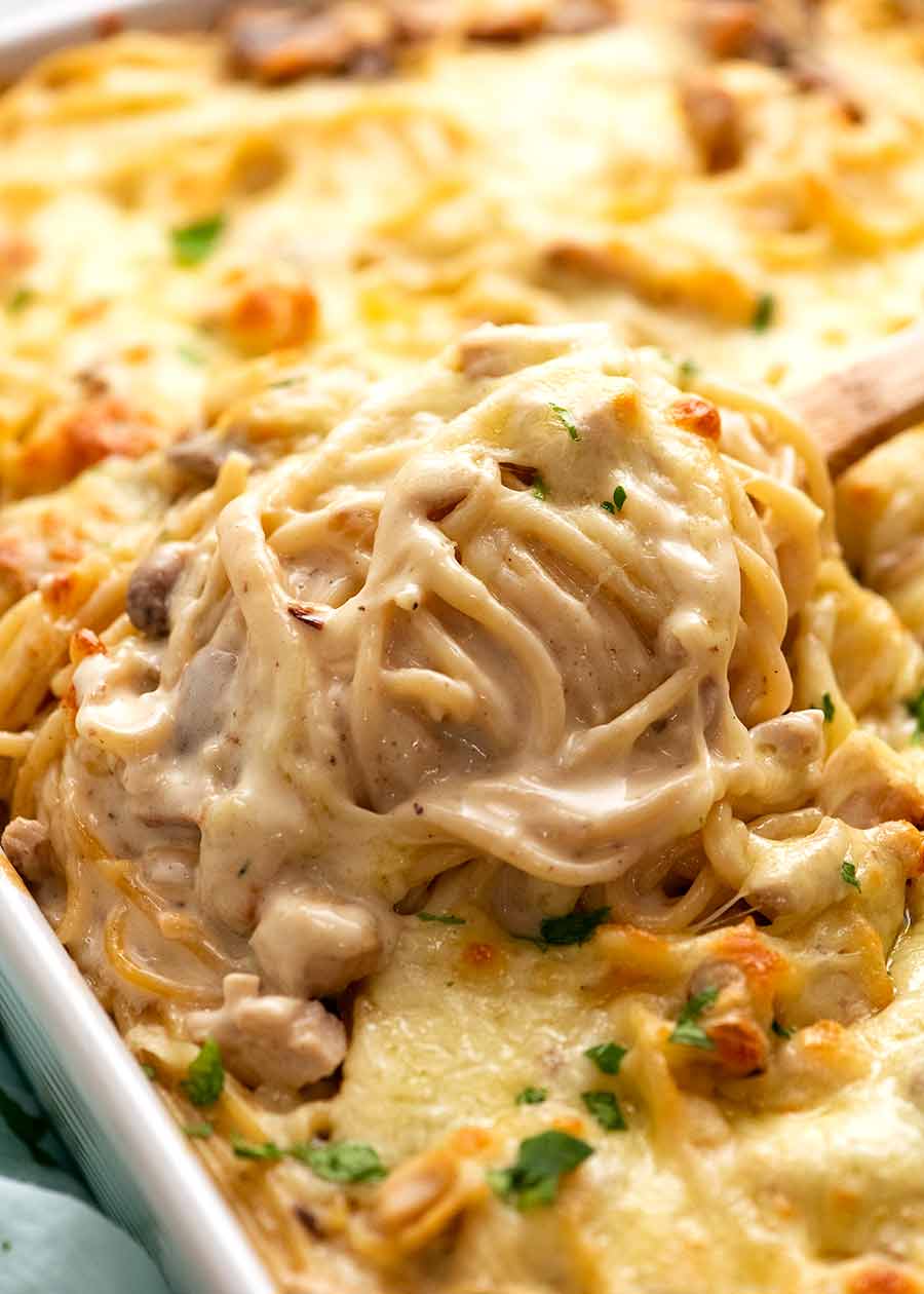 Close up of spoon lifting out some creamy Chicken Tetrazzini fresh out of the oven