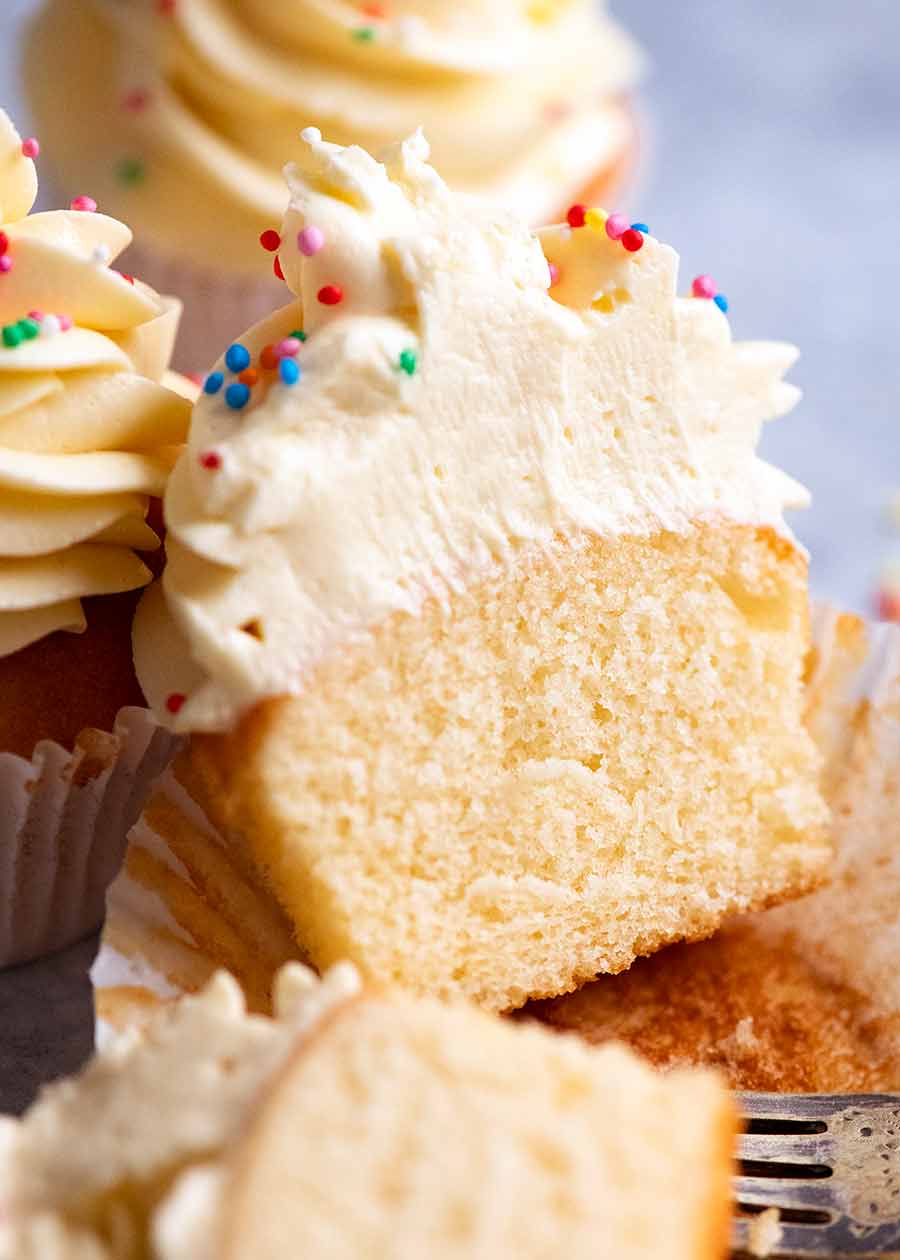 Showing the inside of moist Vanilla cupcakes with vanilla cupcake frosting