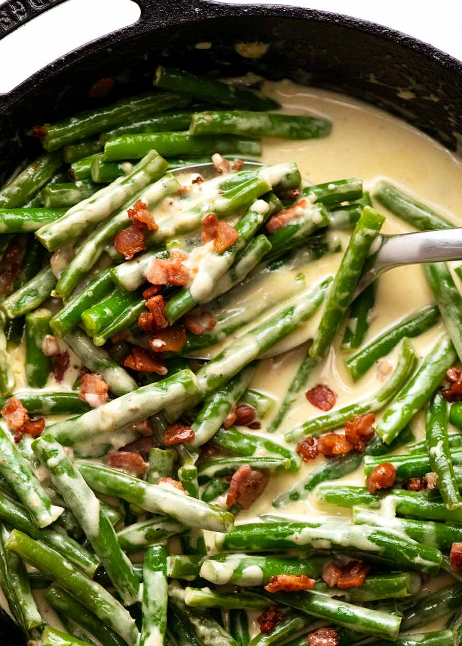 Close up overhead photo of Green beans in creamy parmesan sauce with bacon, fresh off the stove ready to be served