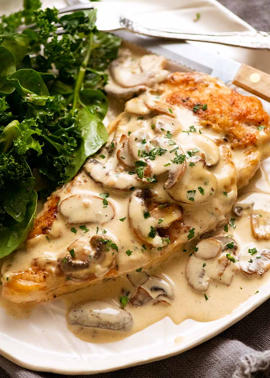 Chicken in Creamy Mushroom sauce on a plate with a side salad, ready to be eaten