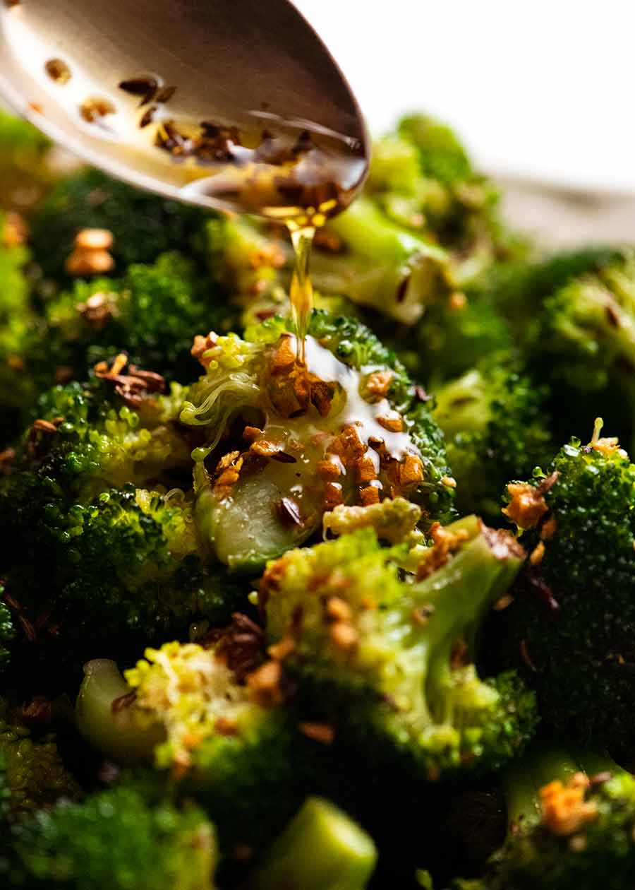 Drizzling garlic and cumin seeds in olive oil over New York Times Broccoli Salad