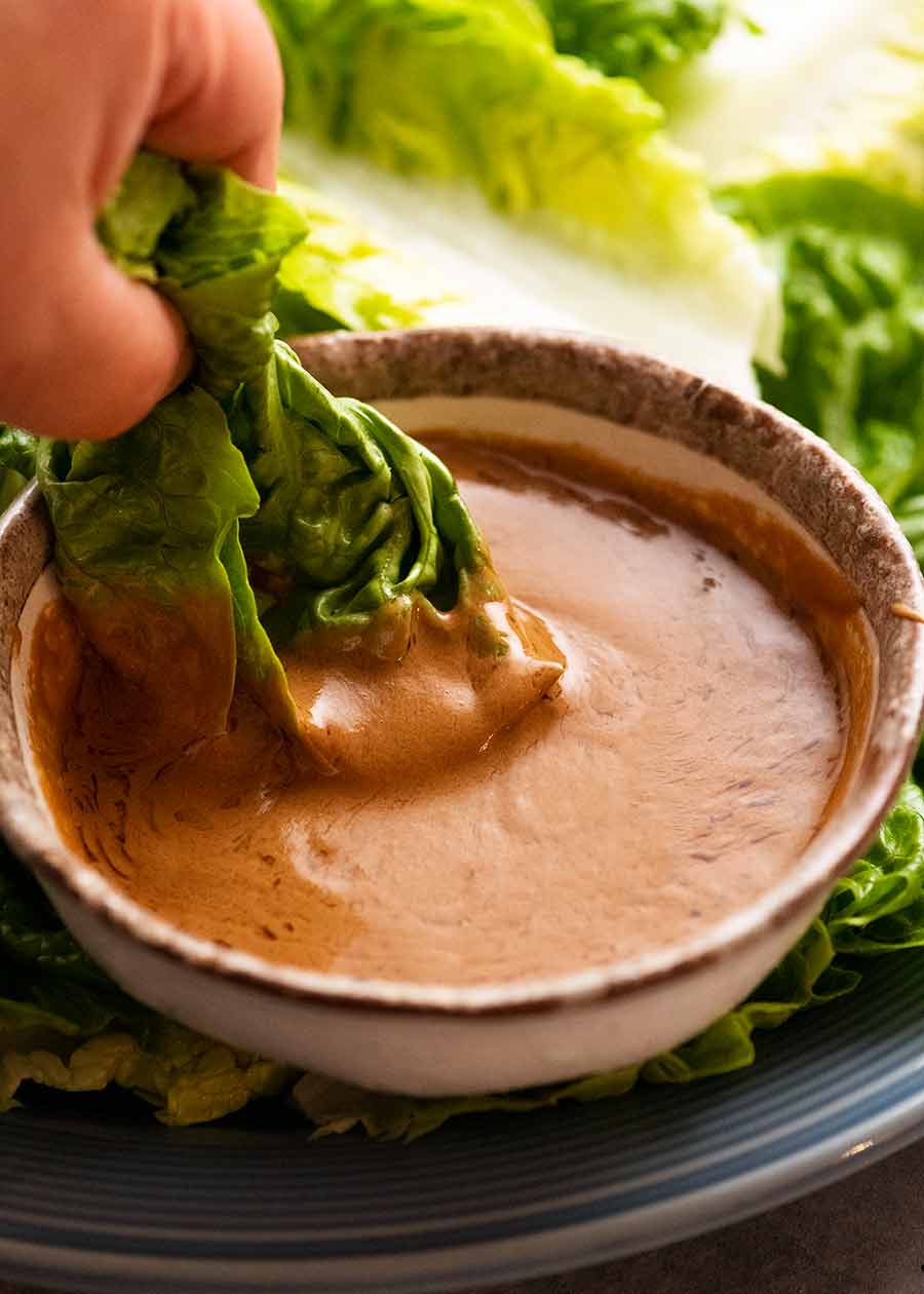 Dipping lettuce into Creamy Sesame Sauce