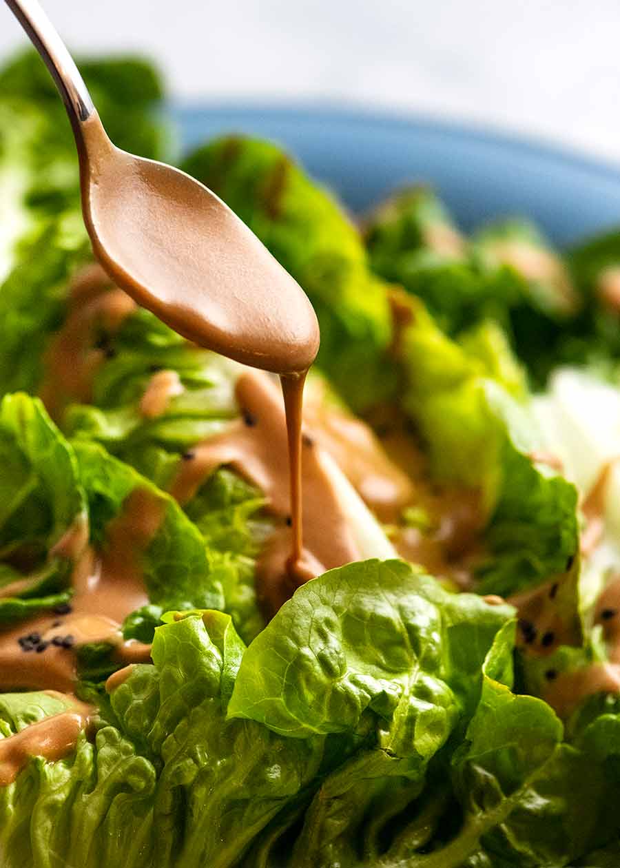 Drizzling creamy Sesame Sauce over lettuce for Spicy Joint Creamy Sesame Sauce Lettuce Salad