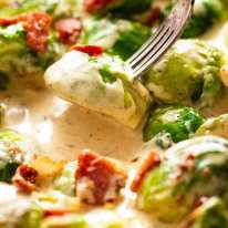 Fork picking up sautéed Brussels sprouts in a creamy sauce