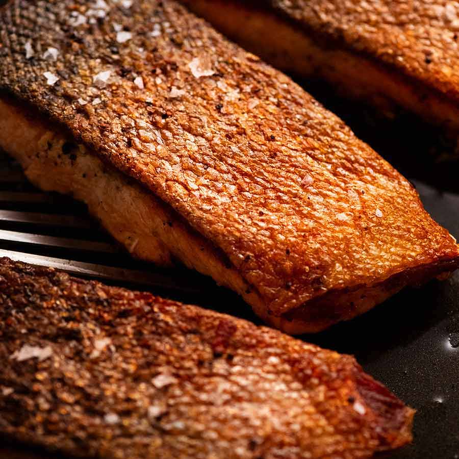 Close up of Crispy Skin Salmon in a skillet, fresh off the stove