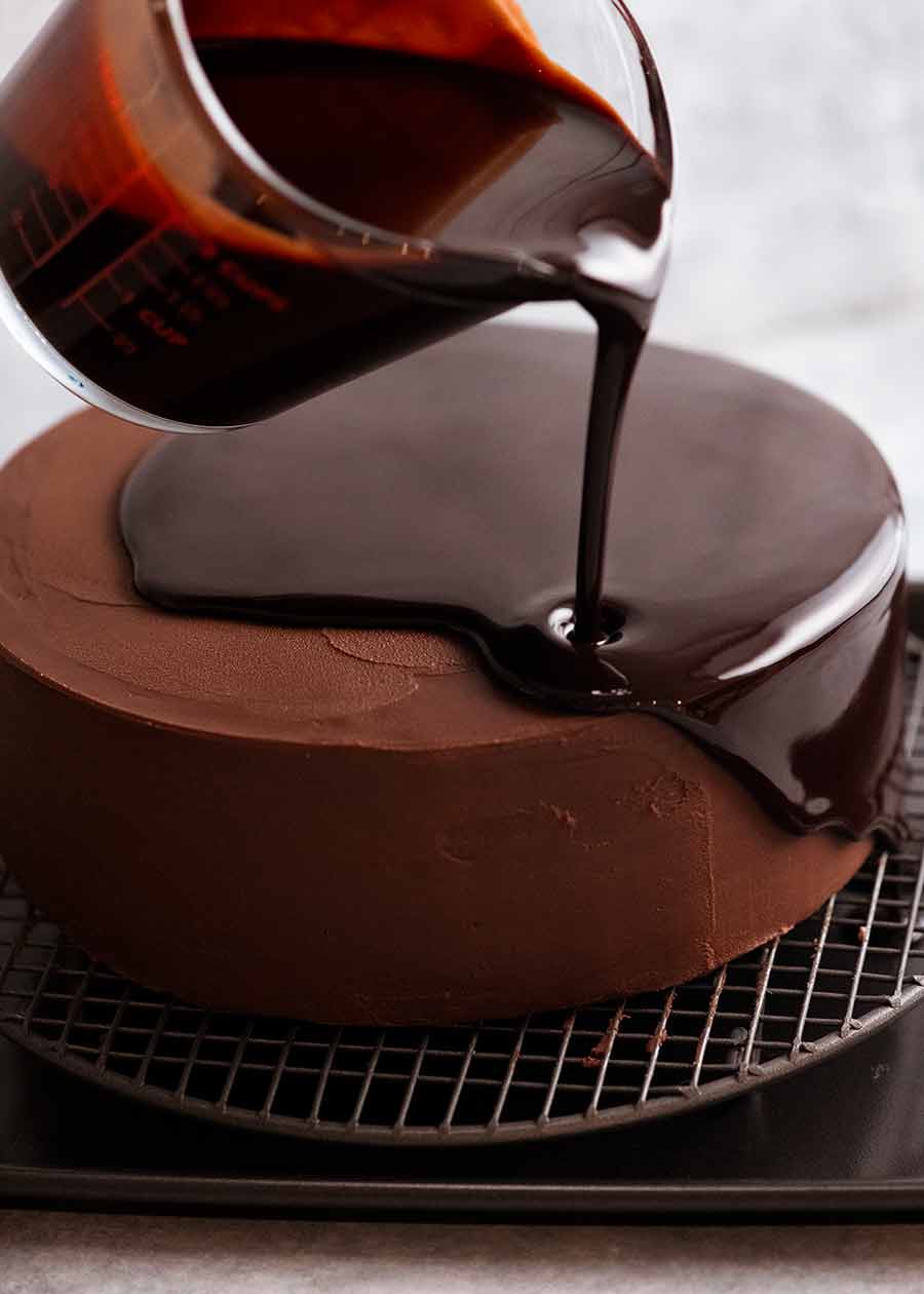 Chocolate Mirror Glaze being poured over cake