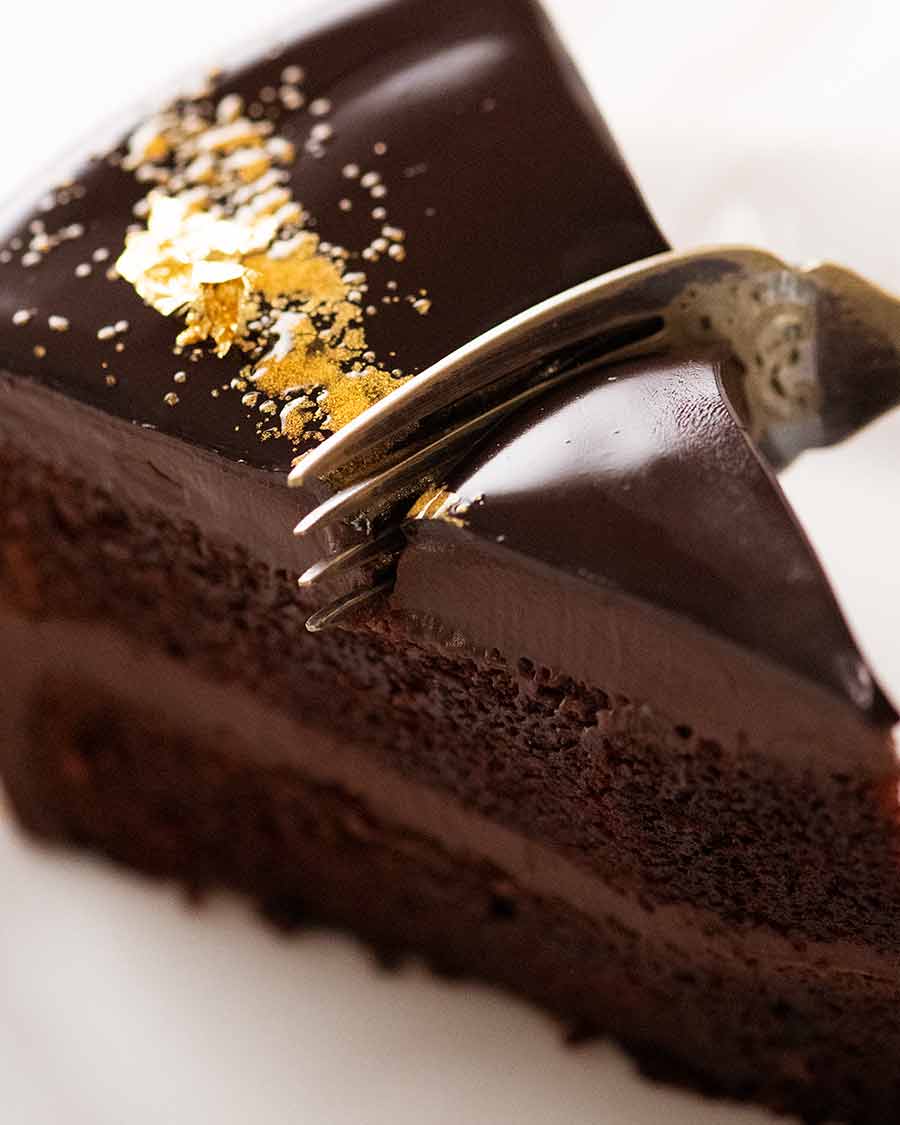 Close up of fork cutting into a slice of Chocolate Mirror Glaze Cake