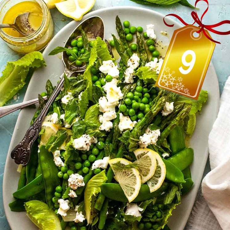 Spring Salad - with asparagus, peas, snow peas, baby cos lettuce (romaine) and goats cheese on a plate, ready to be served