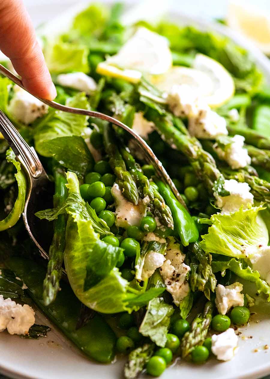 Serving Spring Salad - with asparagus, peas, snow peas, baby cos lettuce (romaine) and goats cheese