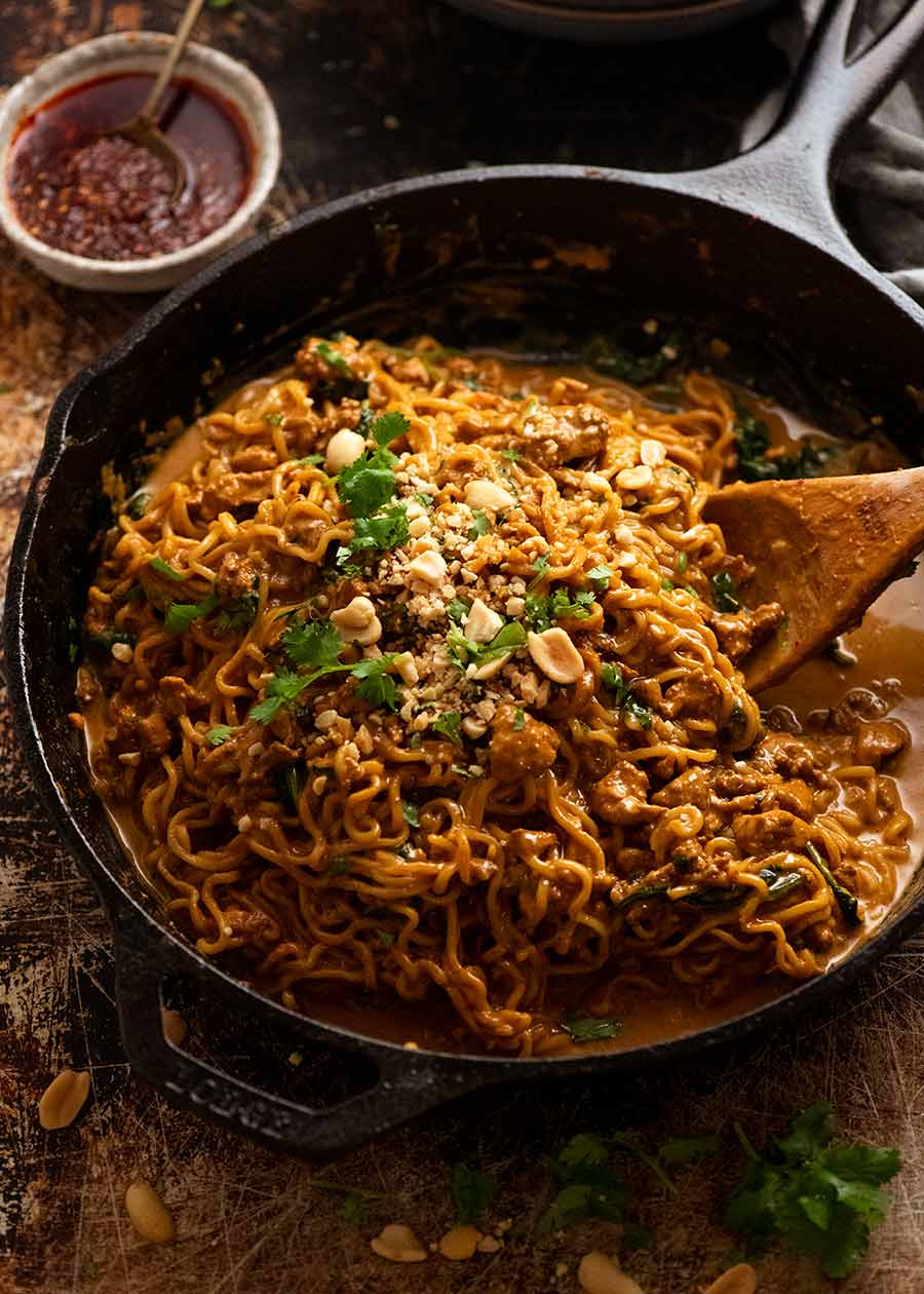 Thai noodles with chicken and peanuts in a skillet, freshly prepared ready to serve