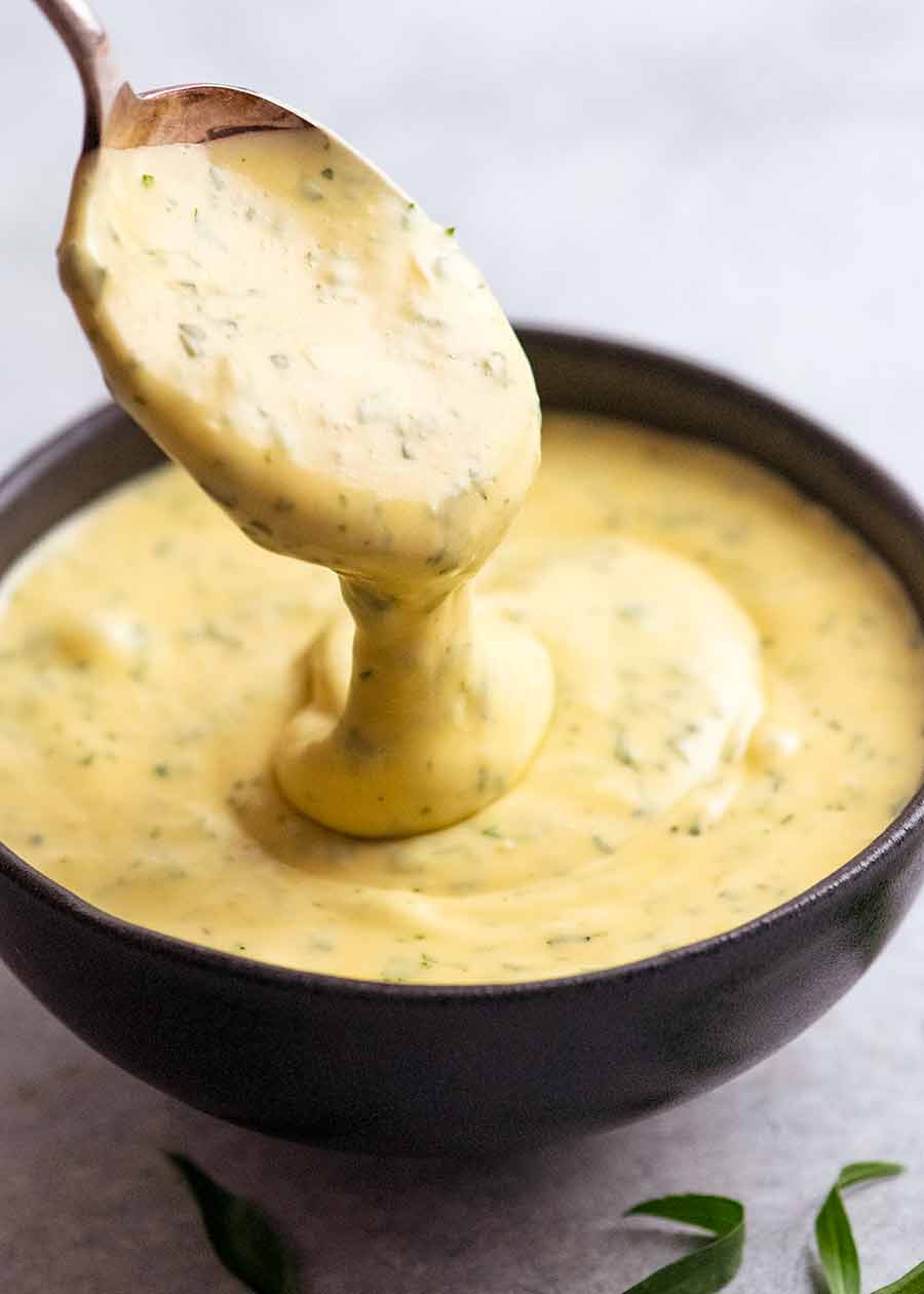 Spoon scooping up Bearnaise Sauce from a bowl