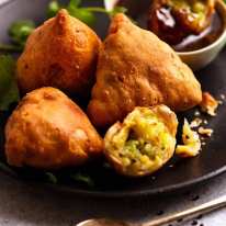 Samosas on a plate with dipping sauce